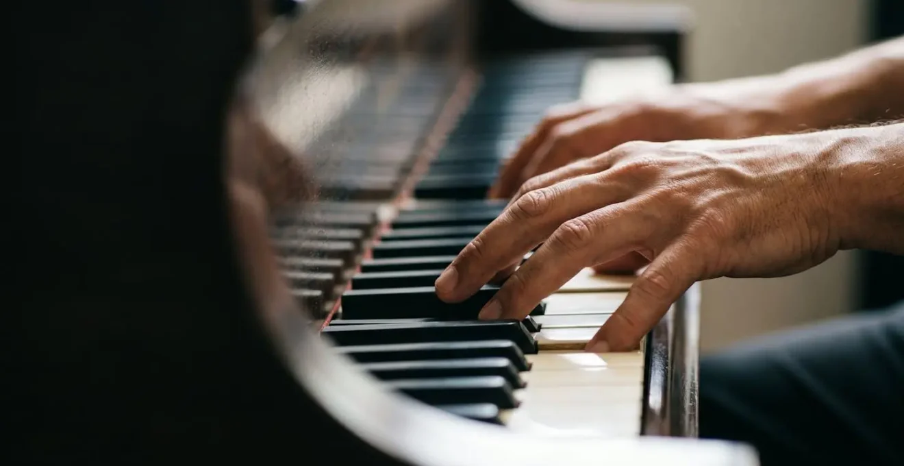 Close-up of musician's hands on piano keys with shallow depth of field emphasizing musical expression