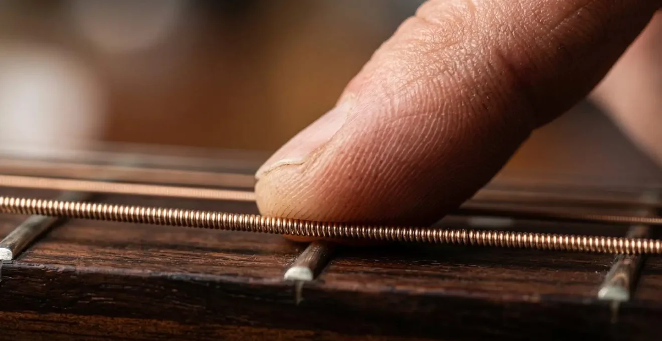Extreme macro detail of musician fingertip texture on instrument surface, emphasizing the tactile sensory connection essential for tone control